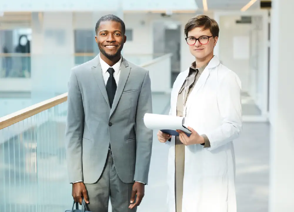 A doctor and lawyer smile while collaborating to support a patient’s case.