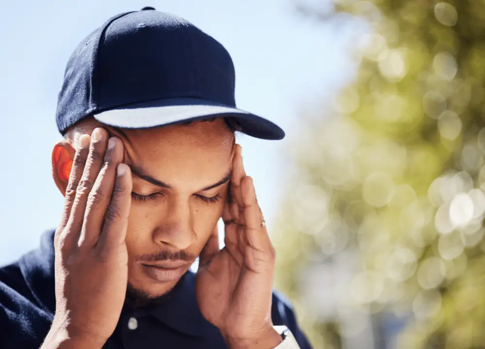 Man feeling dizzy after a car accident holding his head for balance.