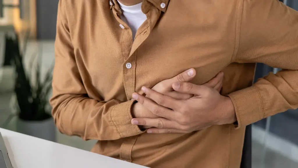 Person holding their side in pain, showing possible rib injury after an accident.