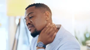 A man holding his neck in pain due to a neck injury.