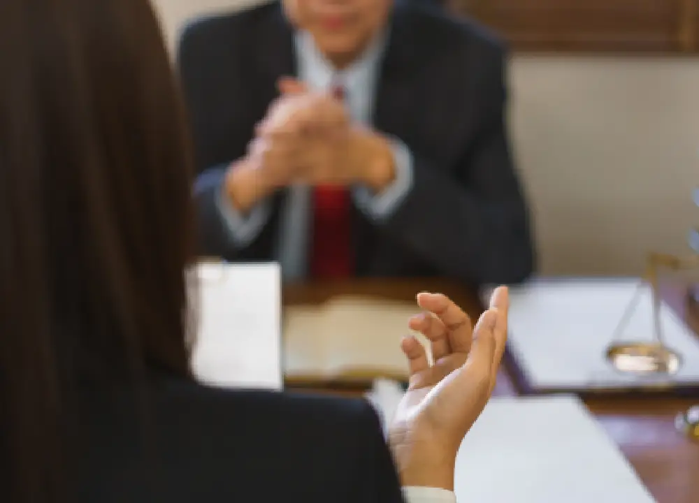 Person consulting with a lawyer in an office, discussing potential damages and legal claims.